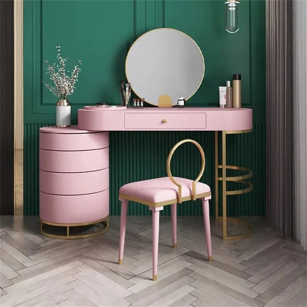 Makeup vanity set in pink color having chair, mirror and table with drawers.